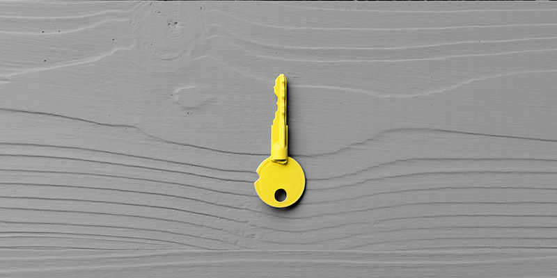 yellow key on grey timber panel background