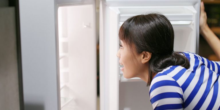 woman looking into fridge